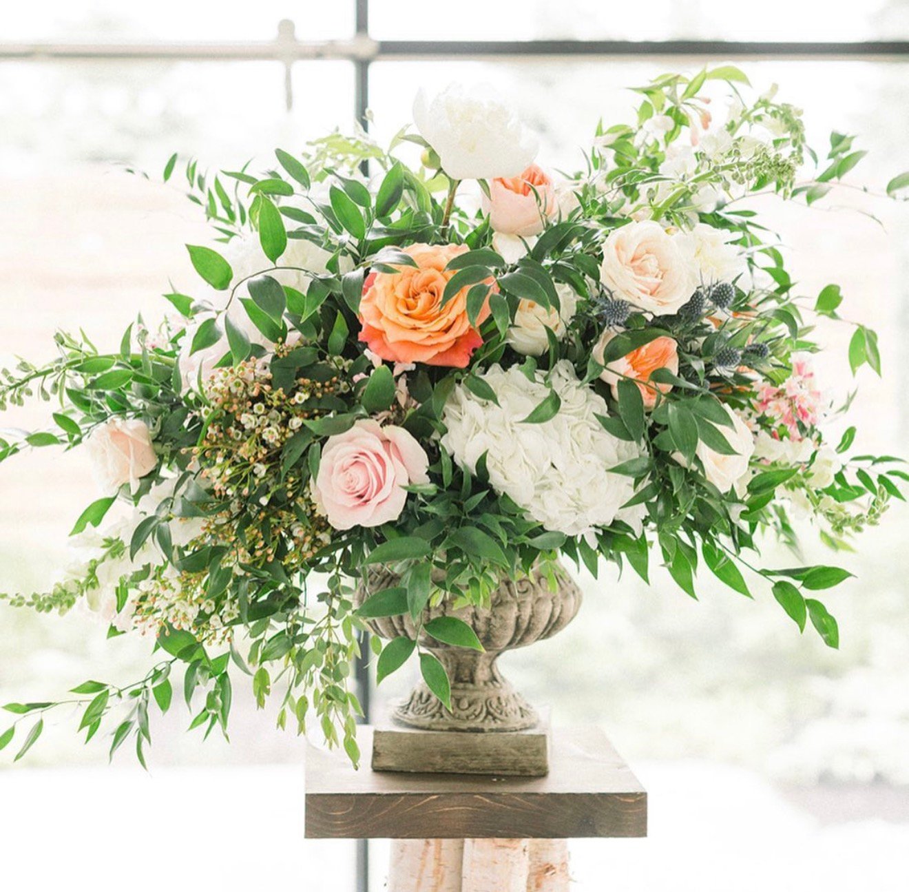 Pink peony and garden rose arrangement in a white vase for a Calgary wedding
